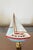 Cute 3” by 3” small sailboat figurine on brass base as lamp finial for coastal home decor.