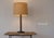Vintage minimalist Danish Modern table lamp with teak and black metal. The base is a hollow domed metal shell. Slick and...