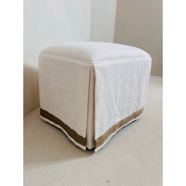 Ivory Linen Skirted Ottoman with tape trim.