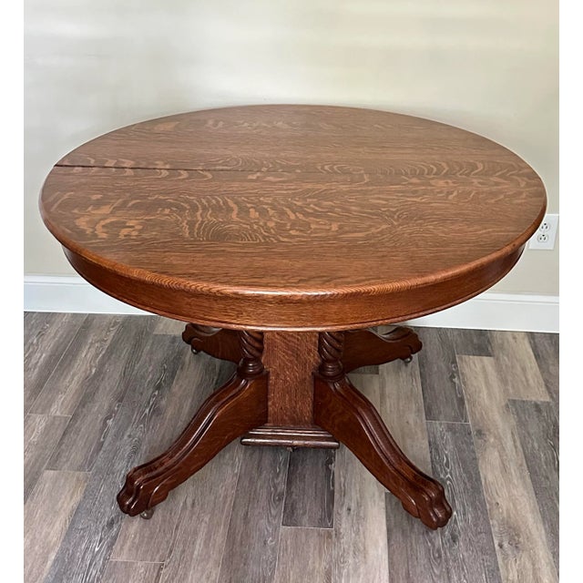 This is a stunning antique quarter-sawn oak table with a split pedestal, 4 leaf extensions and a support leg. Adding the...