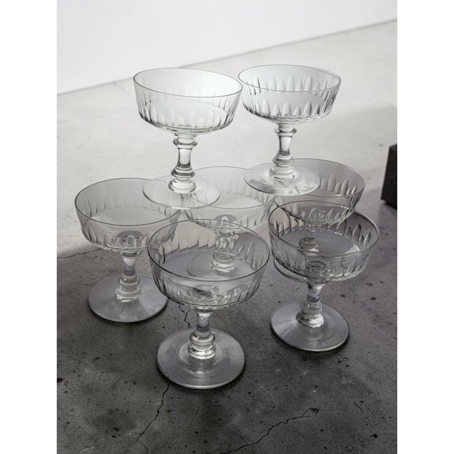 Seven crystal champagne coupes, 1950s-60s. This crystal champagne coupe features an elegant and classic silhouette,...