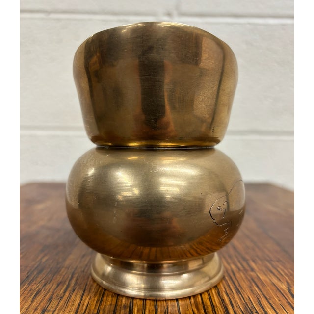 This is a vintage Korean brass pouring vessel with etched beaver motif, featuring a sculptural rounded body, flared angled...