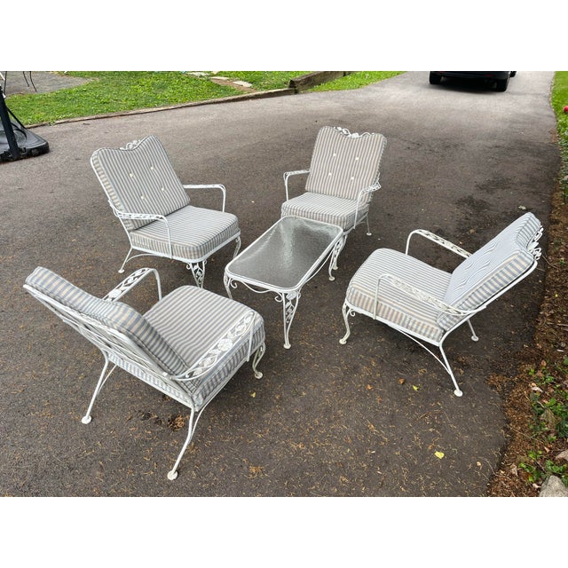 This 1950s Woodard style white Chantilly rose 5 pieces Patio coffee Table and 4 lounge chairs Set is a wrought iron patio...