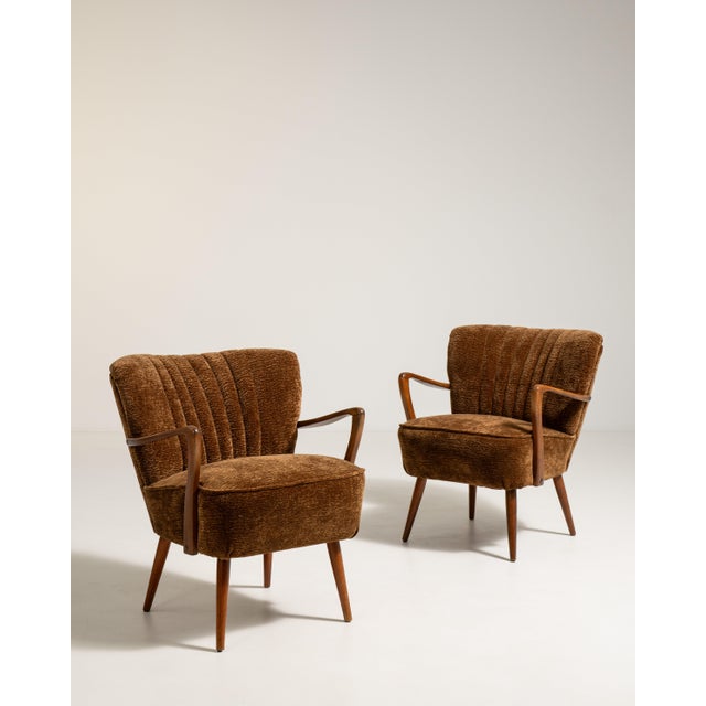 A cohesive pair of Danish shellback armchairs, combining soft curves with structured frames. The paired format enhances...