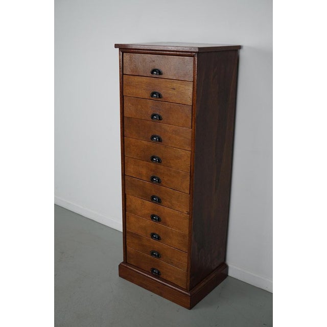 This apothecary cabinet was designed and made from poplar circa 1950 in the Netherlands. It features 11 drawers with black...