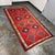 Design Plus Gallery presents a 5ft 8in × 10ft Turkish Kilim Area Rug. This flatweave wool rug displays a vivid red field...