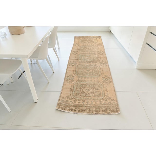 This is a vintage Turkish Oushak rug from the Mid 20th Century. The piece was hand-knotted.