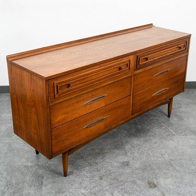 Vintage modern dresser featuring a raised edge, six drawers and rich walnut grain throughout. Manufactured by Broyhill....
