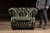 Classic Chesterfield club chair upholstered in deep green leather with a fully button-tufted back and seat rail, rolled...