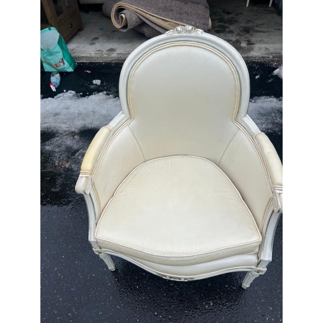 This elegant 1980s vintage upholstered accent chair features a classic French-inspired barrel back silhouette with softly...