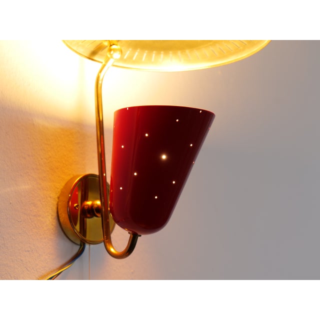 Mid-century Swiss wall lamps by B.A.G. Turgi, clearly influenced by Mathieu Matégot, featuring a perforated brass...