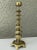 Chinese cast brass candlestick holder in the form of a tall temple or pagoda. It features a thin brass bobeche in the form...