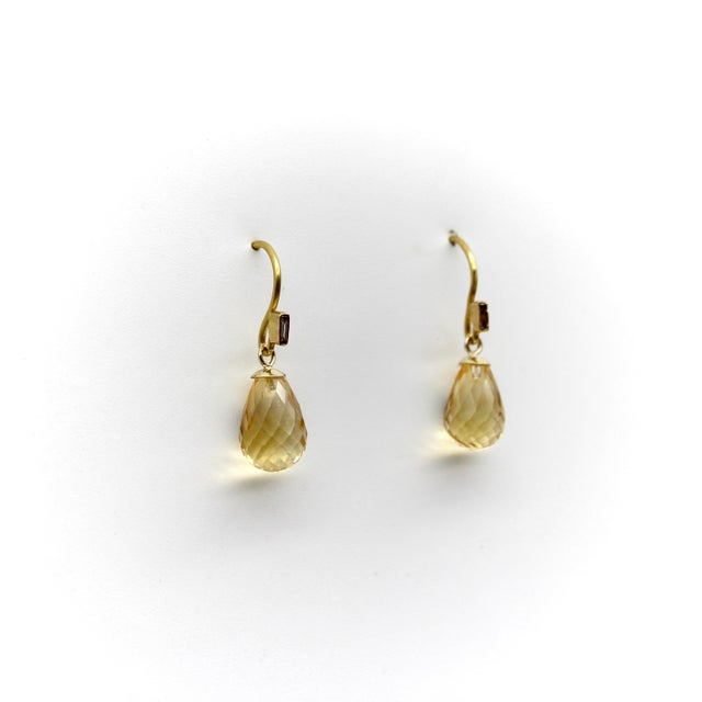 These simple shepherd’s hook earrings are topped with a bezel set baguette diamond that loops around to create a notch for...