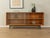 A classic sideboard by Lothar Wegner from the 1960s. High-quality walnut veneer body with two glass sliding doors, two...