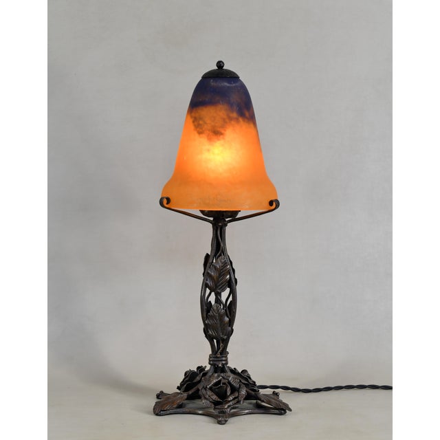 Daum A wonderful 1925-30 French art deco lamp in wrought iron of excellent quality. The forged base holds a large shade in...