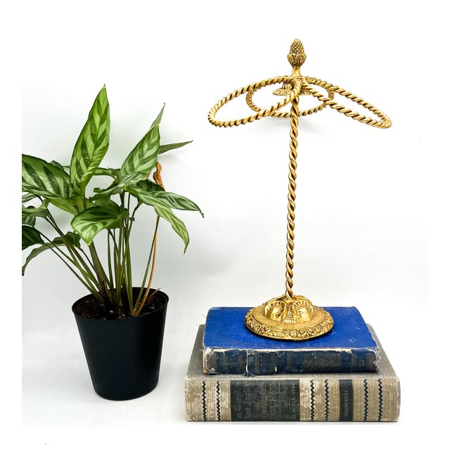 Ornate, mid-late 20th century gilt metal towel holder featuring three twisted-rope rings supported by a coordinating...