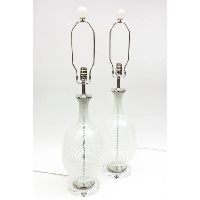 This pair of vintage Murano Italian Aureliano Toso white swirled glass lamps have chrome appointments and the wonderful...