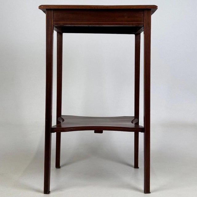 A refined and beautifully crafted early 20th-century English Edwardian side table, finely constructed in mahogany and...