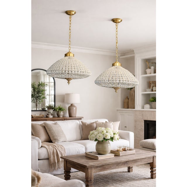 A beautiful pair of French bronze and crystal chandeliers, crafted circa 1960. These elegant vintage chandeliers combine...