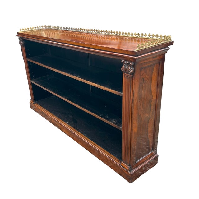 Rectangular top with bronze gallery over two adjustable shelves. The whole flanked by fluted columns with carved...