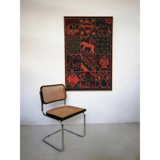 A large African batik fabric in warm, earthy colours. Animal figures and decorative geometric elements alternate within a...