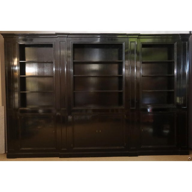 A three-bay blackened wood bookcase with pilasters, the central bay slightly projecting. It features nine adjustable...