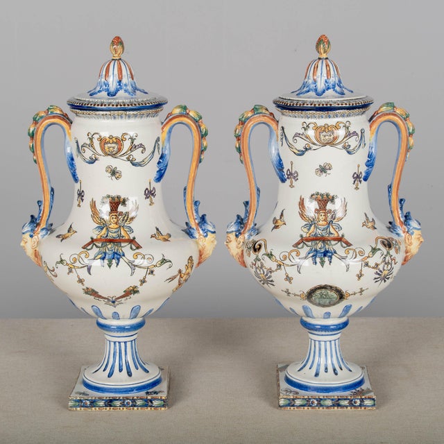 A pair of 19th century French Gien faience urns with hand-painted decoration. Nice form with double handles and square...