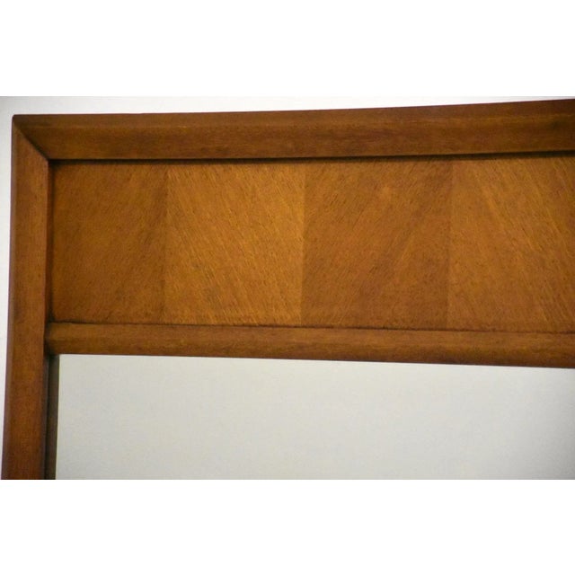 A mid century, modern, walnut square mirror.