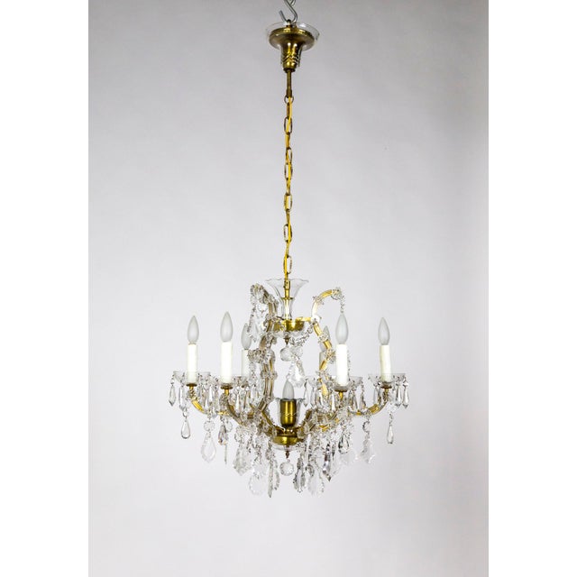 A six-arm, brass and glass chandelier in the Maria Theresa style from the mid-20th century with many large, dangling...