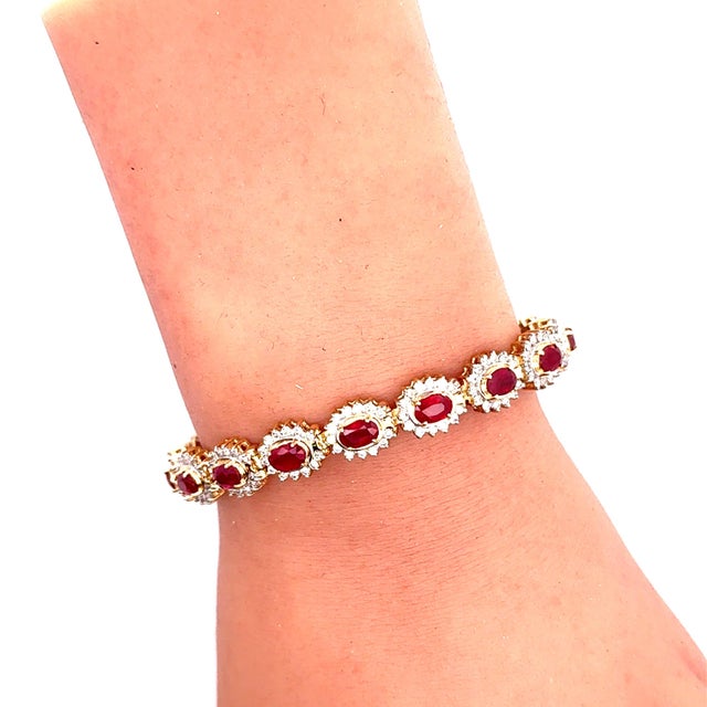 A contemporary link bracelet crafted in 14k yellow gold. The design features oval shape rubies, totaling 10.36 carats, set...