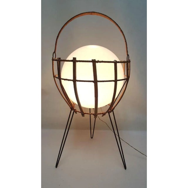 This floor lamp from the 60s features a white opal blown glass sphere enclosed in a metal and bamboo basket. European Plug...