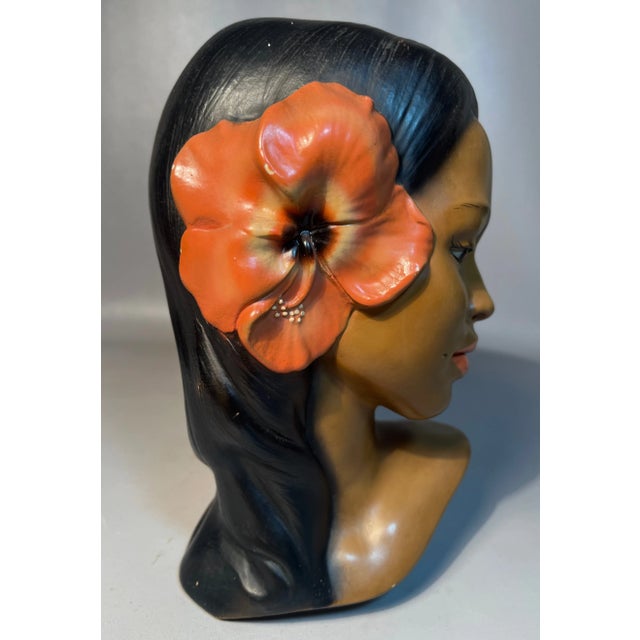 Usher in a bit of Pacific Islands Culture with this sculpted bust of a Polynesian woman. She is hand painted with a coral...