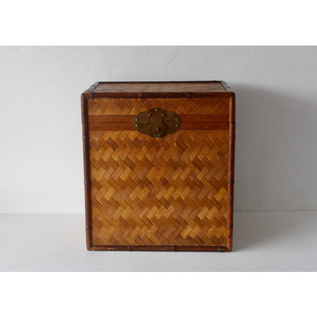 A vintage bamboo and woven rattan chest featuring a faux bamboo frame and brass hardware. Handles on both sides and a...