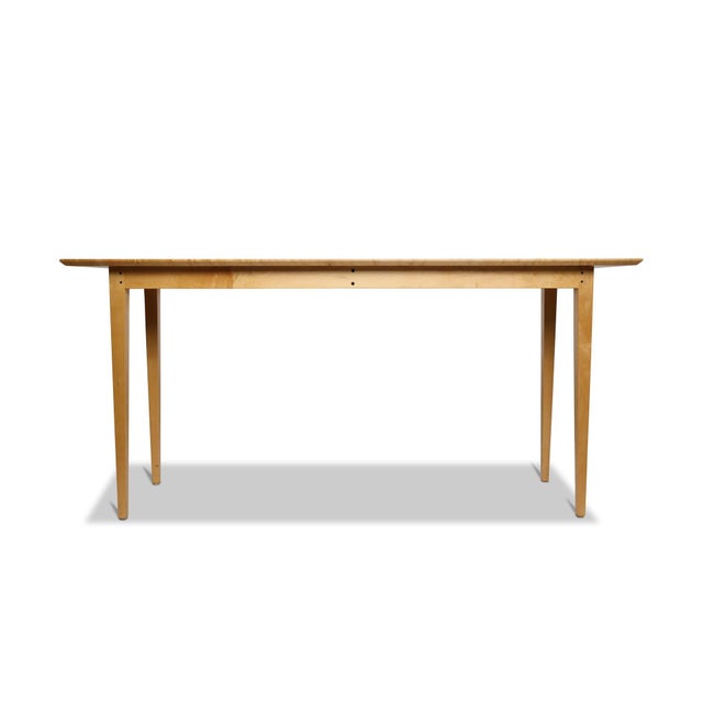 Minimalist console table finely handcrafted of solid bird’s-eye maple with exceptional figured grain. Features a slender...