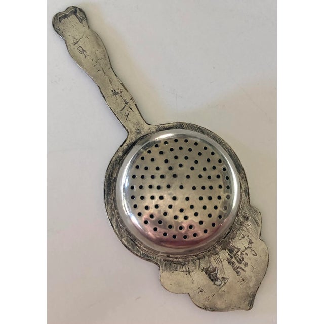 This lovely tea strainer is embossed on the handle and extended rim with country European life and has a bowl deep enough...