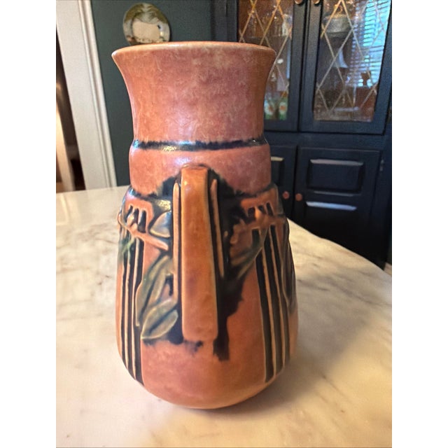 The Roseville Laurel Art Pottery Persimmon Color Vase #667-6 from 1934 is a beautifully crafted piece of art pottery. With...