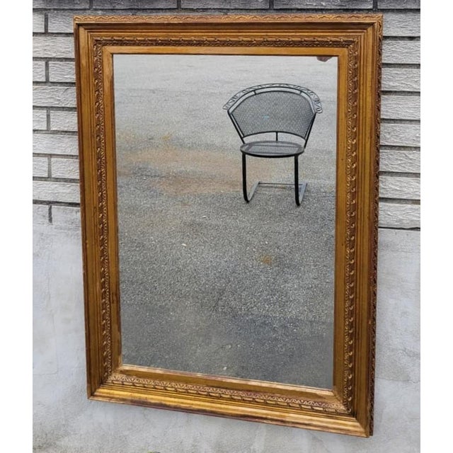 Beautiful 19th Century French gilded wall mirror featuring an elegant carved wood frame with rich gold finish and timeless...