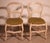 Two polychrome wooden straw-seated chairs. Model with a rounded back and double crossbar. Legs joined by wooden stretchers...
