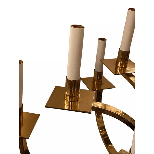 22” across 29” tall This exquisite Mid-Century Modernist chandelier features a two-tier brass frame candelabra form design...