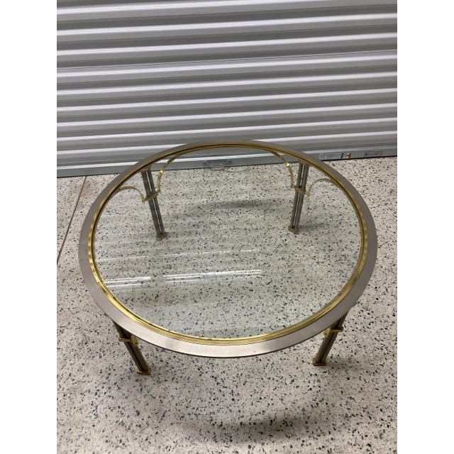 A lovely mid-20th Century two-tone brass and chrome round coffee table with a glass inset top in the style of Maison...