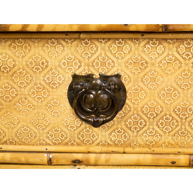 An English small bamboo chest from the early 20th century with floral décor, mottled effects, three drawers and metal...