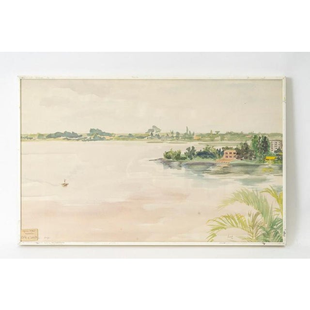 Framed watercolor on paper under glass by Evelyne Luez. Framed watercolor on paper under glass depicting a river in Ivory...