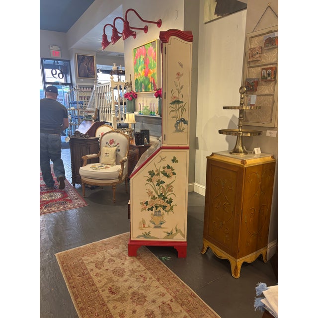 This is a 20th century vintage chinoiserie secretary cabinet. It features fabulous hand painted floral motifs and scenes....