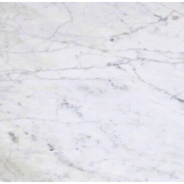 The teardrop-shaped top and the two legs are made of magnificent Carrara marble featuring a beautiful pattern. The...