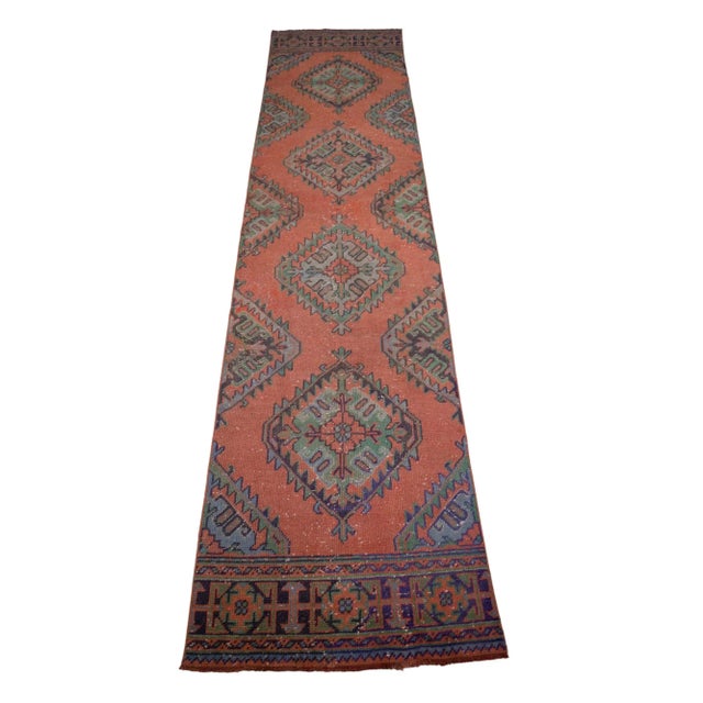 This vintage Turkish rug is a distressed runner with a bold pattern with muted colors. The style is complementary to any...