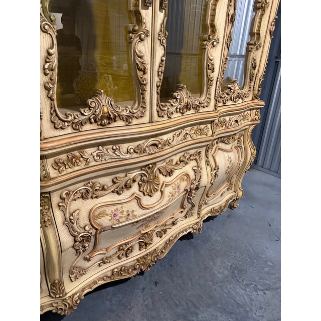 Monumental Rococo Revival china cabinet and buffet featuring an exceptionally ornate cream-and-gold finish, elaborate...