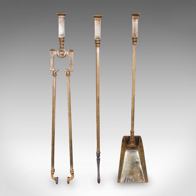This is a trio of antique fireside tools. An English, brass poker, coal shovel and tongs companion set, dating to the...