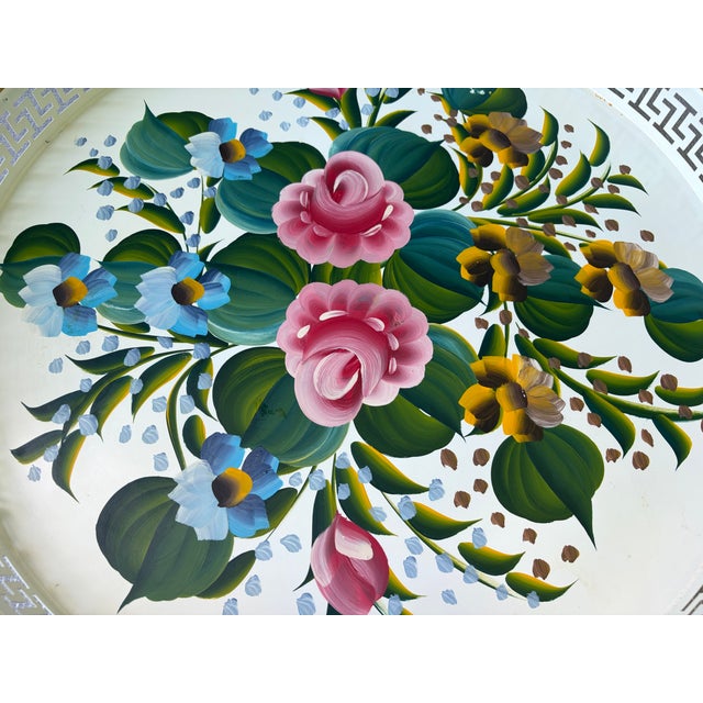 Pretty, round vintage white floral tole painted tray with a wide reticulated rim. Center if covered in. a floral leaf...