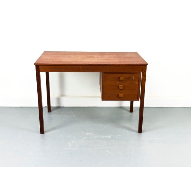 Danish teak desk with three drawers. Clean-lined design in a compact size, ideal for small spaces. • Manufacturer: Domino...