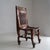 An impressive solid wooden Egyptian Revival chair with gilt accents and lion paw feet. Under the lion paw feet copper...